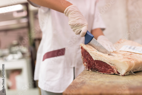 Butcher woman cutting meat.