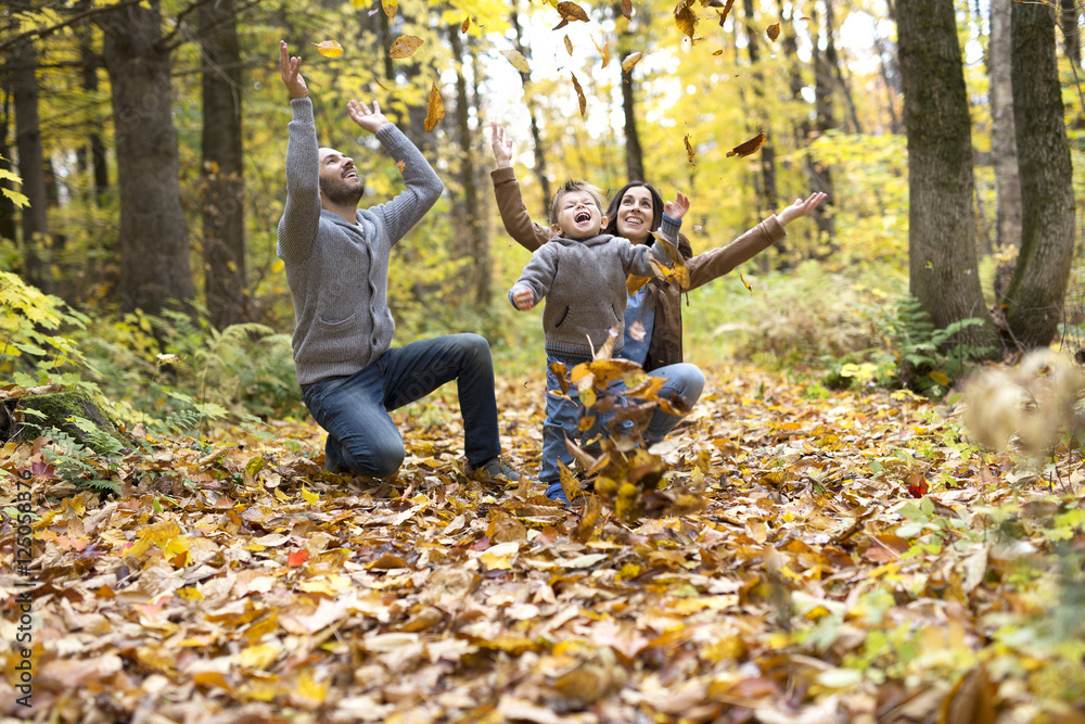 Happy family relaxing outdoors In autumn park