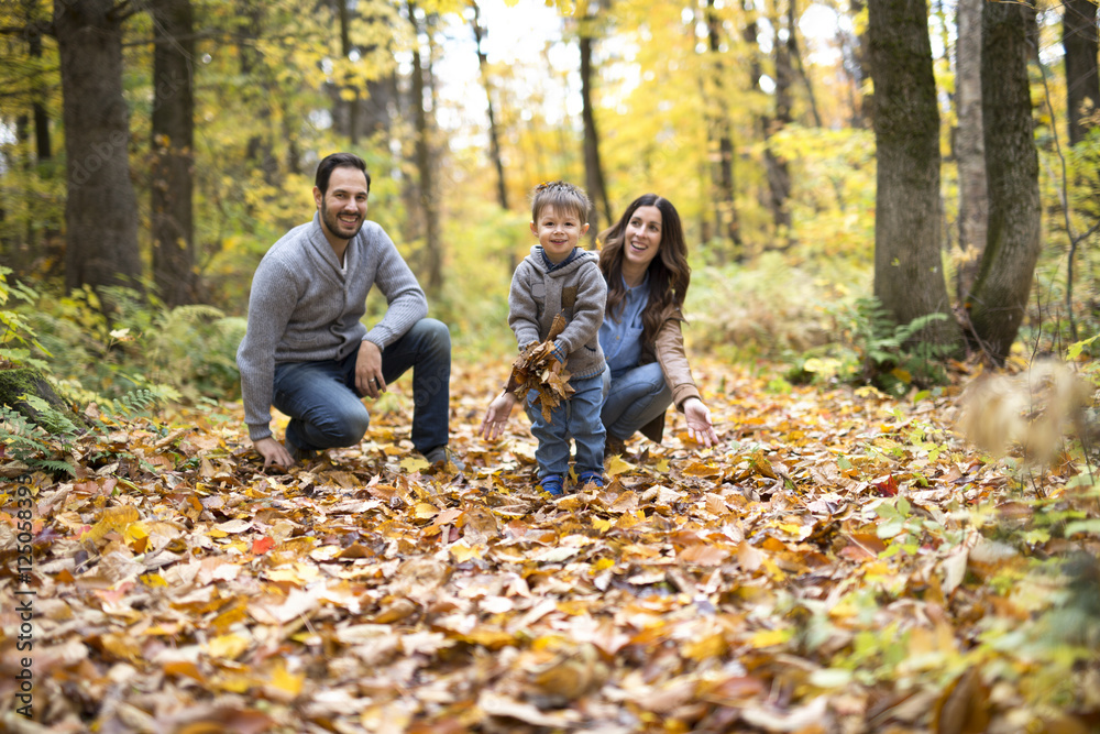 Happy family relaxing outdoors In autumn park