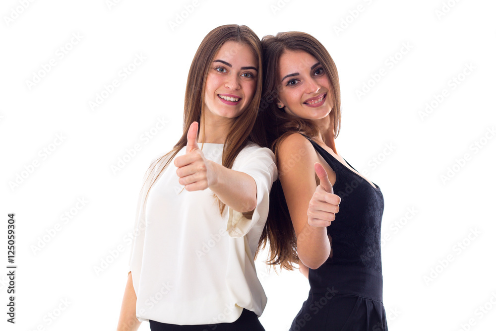 Two young woman showing thumbs up Two young woman showing thumbs up