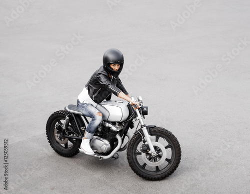 Biker woman in leather jacket on motorcycle