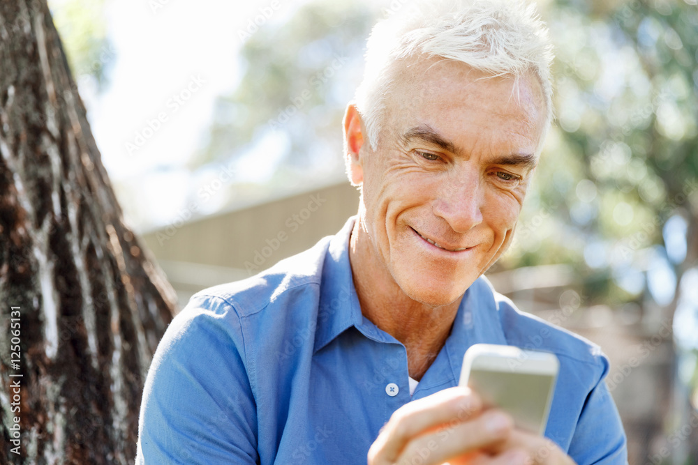 LoMature man outdoors using mobile phone LoMature man outdoors using mobile phone