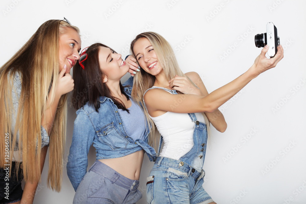 Happy girls friends taking some pictures with camera Happy girls friends taking some pictures with camera