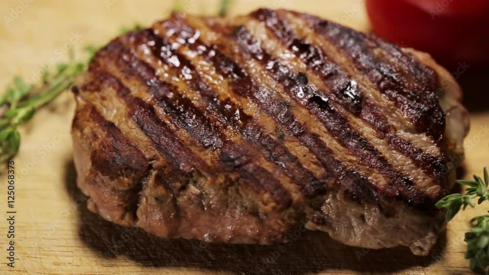 Closeup of grilled steak on the wooden surface Closeup of grilled steak on the wooden surface