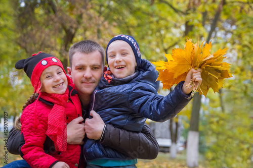 Father with two children in autumn park