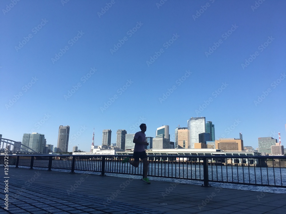 Runner on urban riverside path