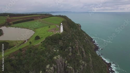 Beautiful cinematic flight around Table Cape Lighthouse revealing rugged cliffs and countryside, Tasmania, Australia