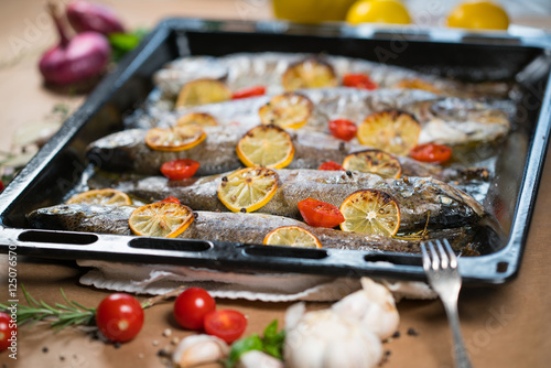 delicious trout fish baked with lemon, tomatoes and spices
