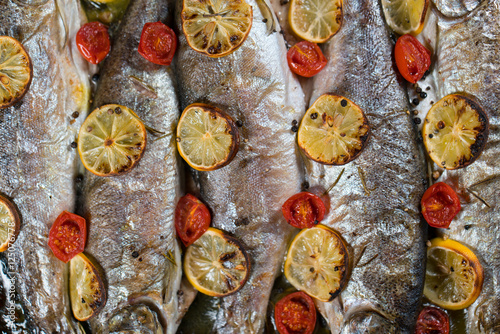 delicious trout fish baked with lemon, tomatoes and spices