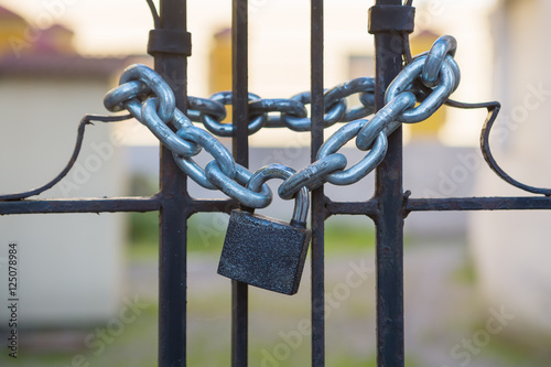 padlock and strong steel chain wrapped around the metal entrance