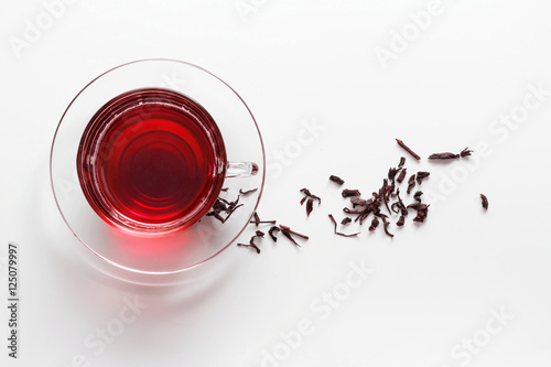 transparent glass cup with Hibiscus tea on the saucer with dry t