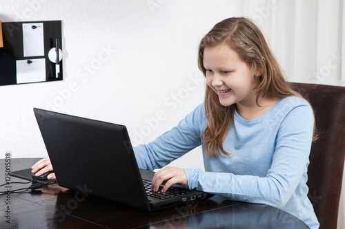 girl looking to her laptop and smiling