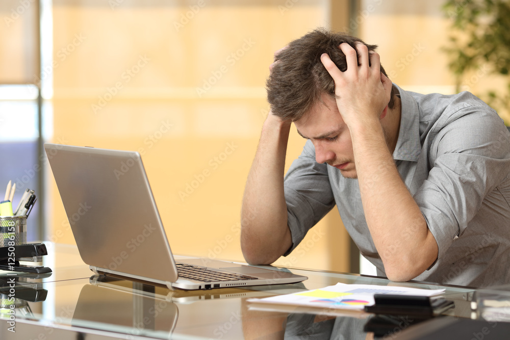 Worried businessman lamenting at office Worried businessman lamenting at office