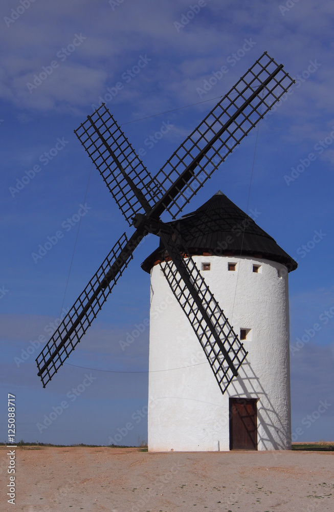 A white Windmill against a blue sky in landscape format.