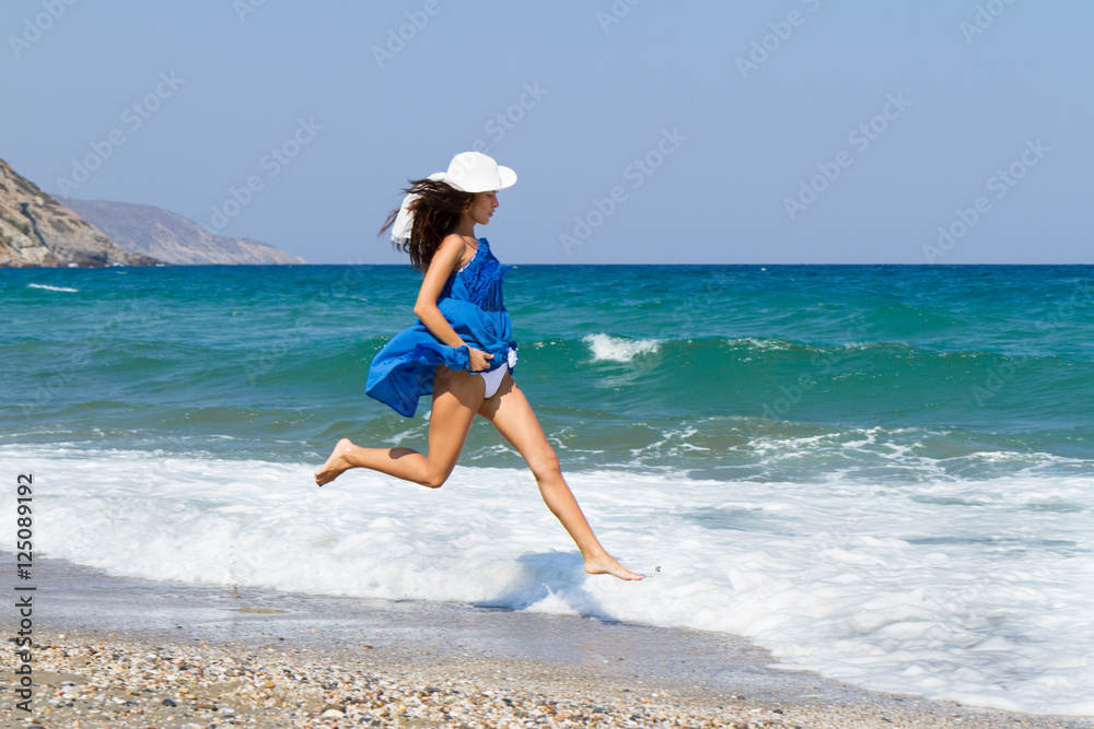 Beautiful stress free woman with blue dress at the beach Beautiful stress free woman with blue dress at the beach