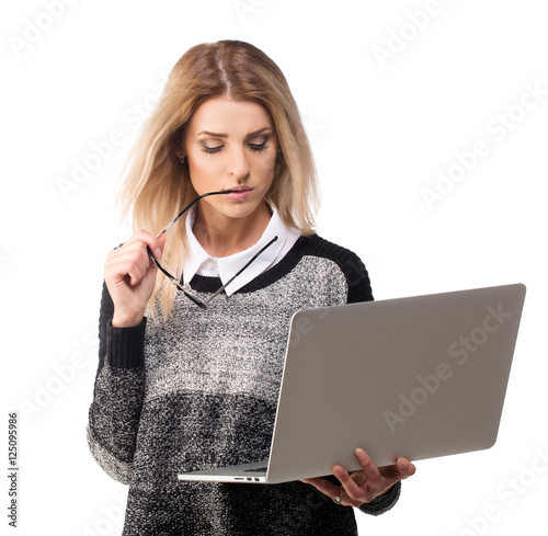 Serious student thinking with a laptop, stylish woman in casual