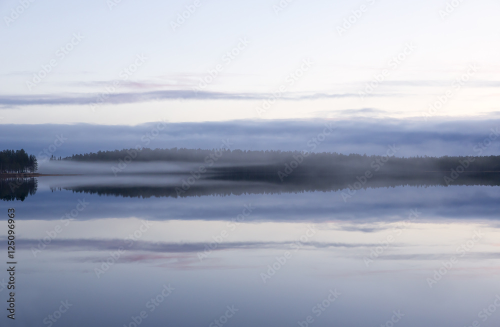 Magical view. Foggy landscape at the lake during night time in Finland