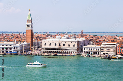 Aerial view of a boat sailing in front of the famous San Marco Campanile and the Doges Palace on the Grand Canal in Venice, Italy.