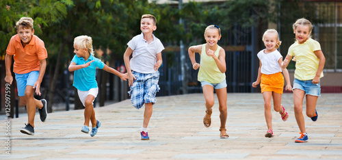 Group of children running outdoors in city street