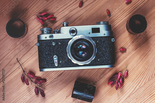 Vintage film camera with films on wooden background photo