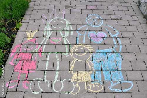 En lycklig familj ritad på gatan med kritor i färgglada färger.  photo