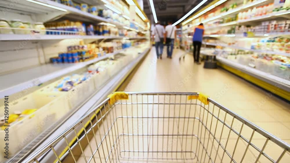 moving shopping cart in a large supermarket moving shopping cart in a large supermarket