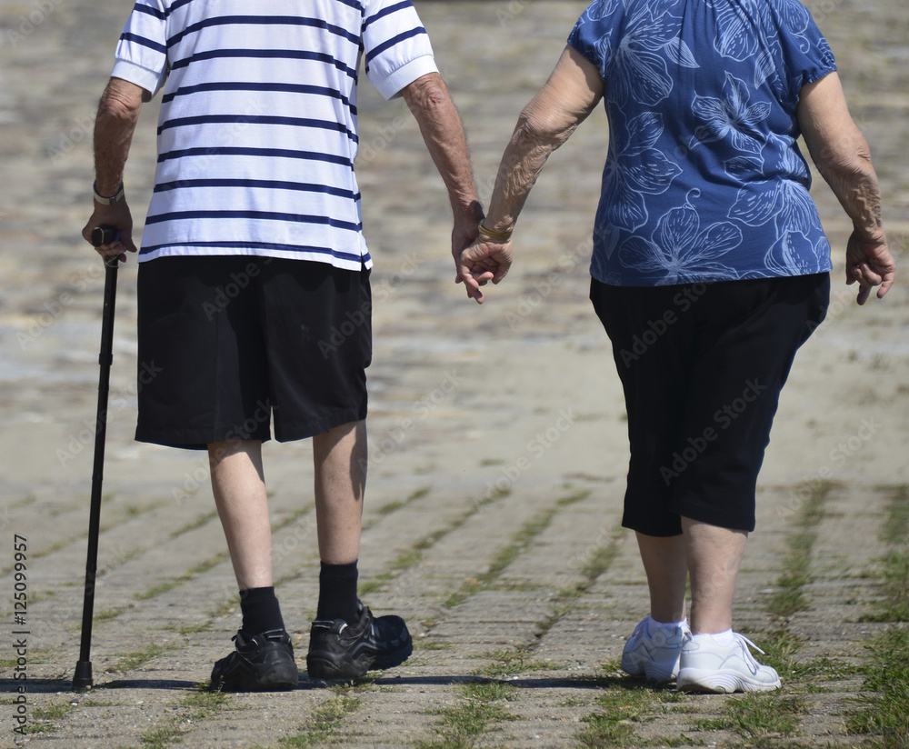 Senior couple walking holding hands - Concept of love and family union Senior couple walking holding hands - Concept of love and family union