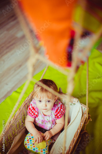 Look from above at a little child sitting in the basket of toy b