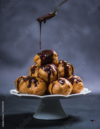 Topping profiterole tower with chocolate