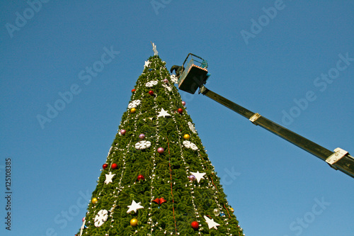  A worker decorates a Christmas tree photo