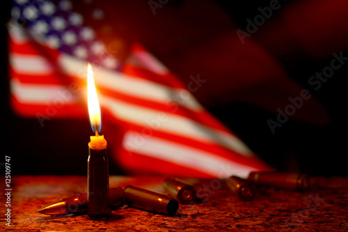 Candles flag tragedy in USA weapons dark background.