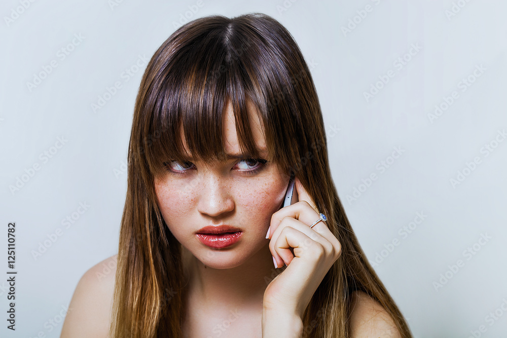 Pretty girl portrait talking on the phone and listening carefully Pretty girl portrait talking on the phone and listening carefully