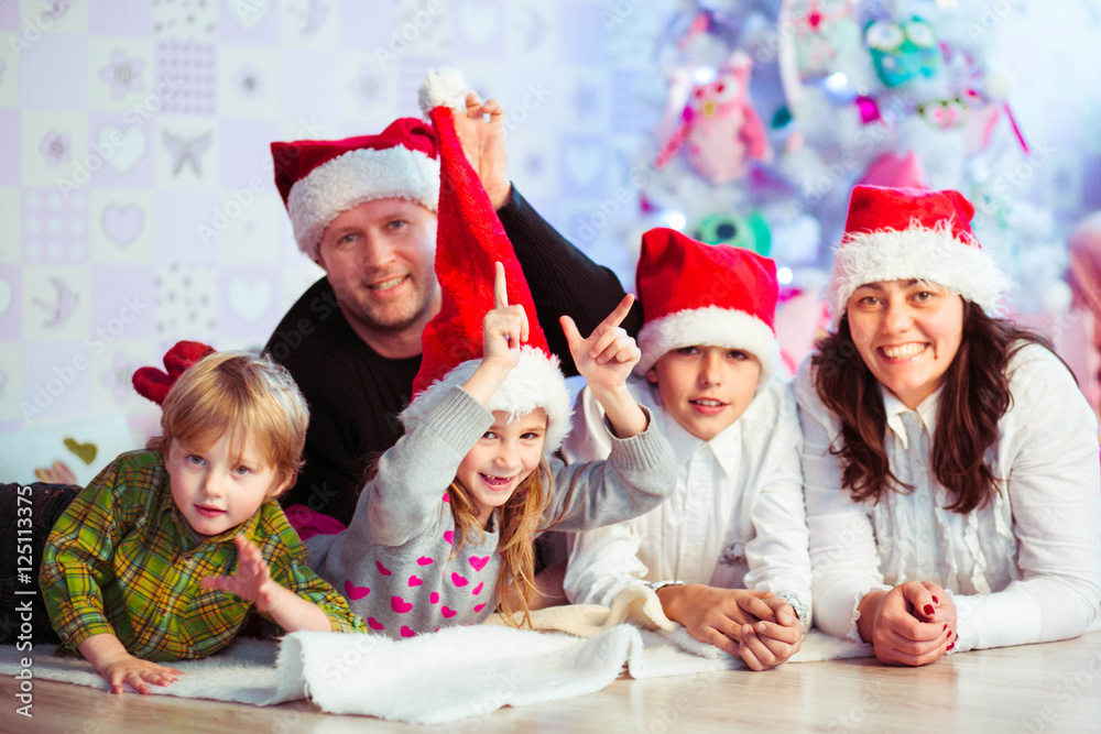 happy and beautiful family sitting together in red hats happy and beautiful family sitting together in red hats