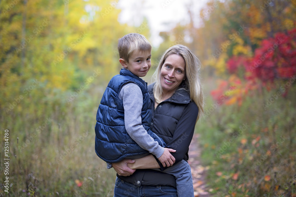 Fototapeta premium Mother with son in forest in autumn