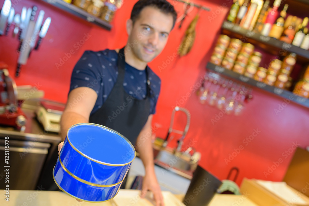 Fototapeta premium Man in deli holding blue tin