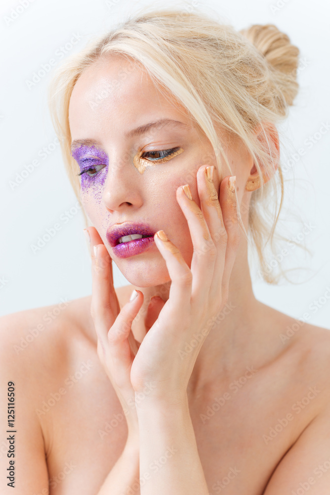 Fototapeta premium Zmysłowa młoda kobieta dotyka jej twarzy z kreatywnym makijażem