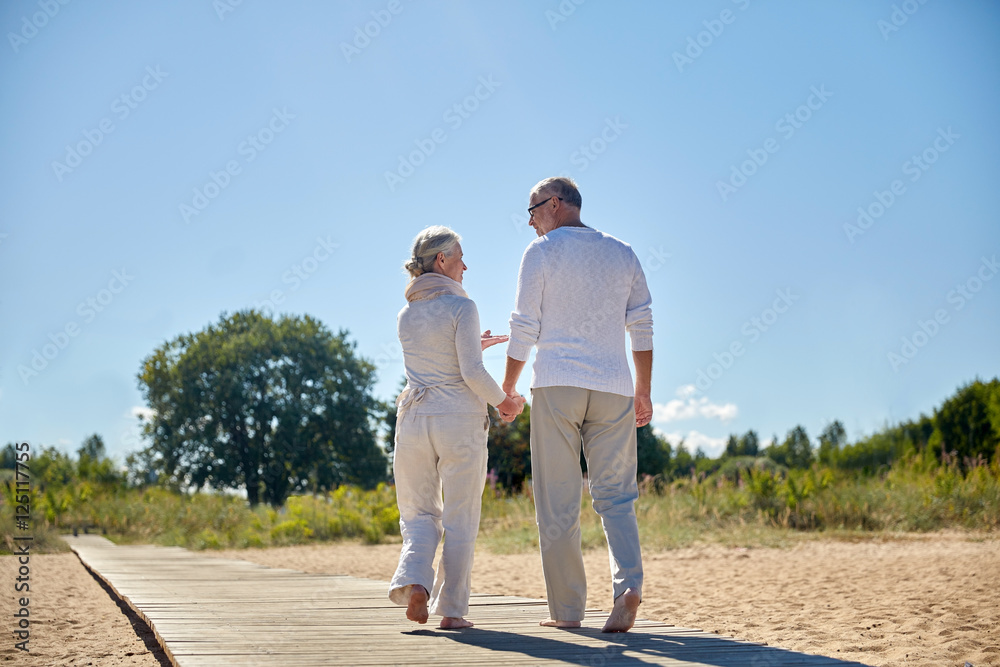 happy senior couple holding hands on summer beach happy senior couple holding hands on summer beach