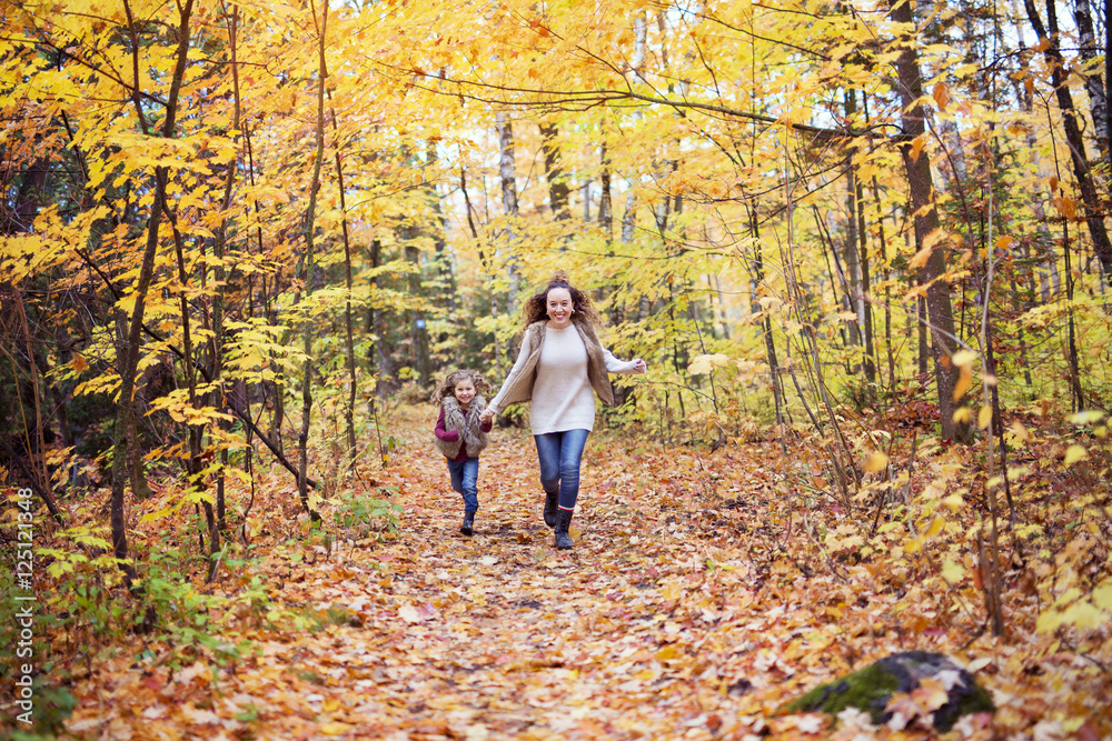 Young mother playing with her daughter in autumn park Young mother playing with her daughter in autumn park
