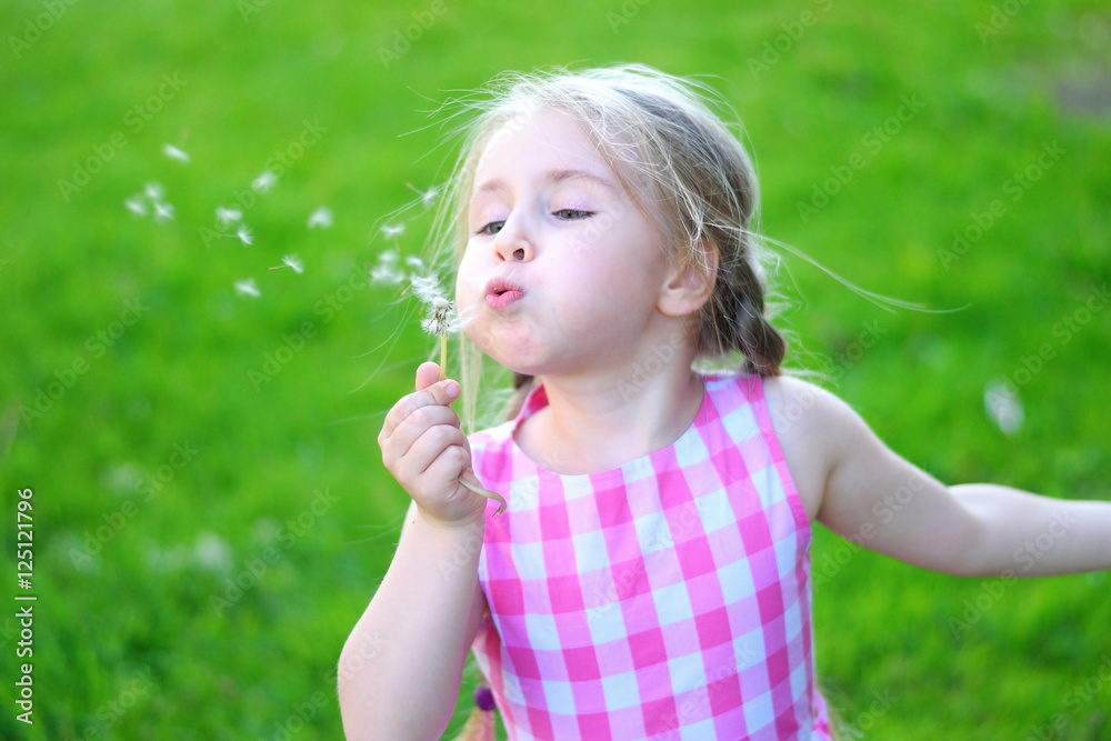 Adorable little girl blowing on white dandelion Adorable little girl blowing on white dandelion