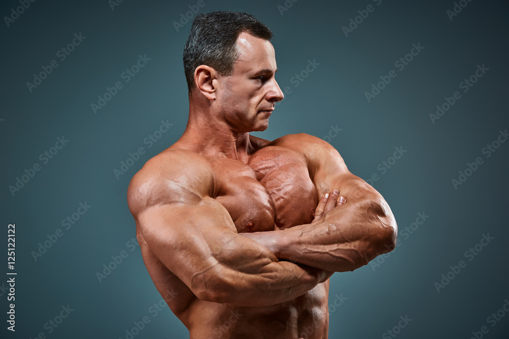 torso of attractive male body builder on gray background. torso of attractive male body builder on gray background.