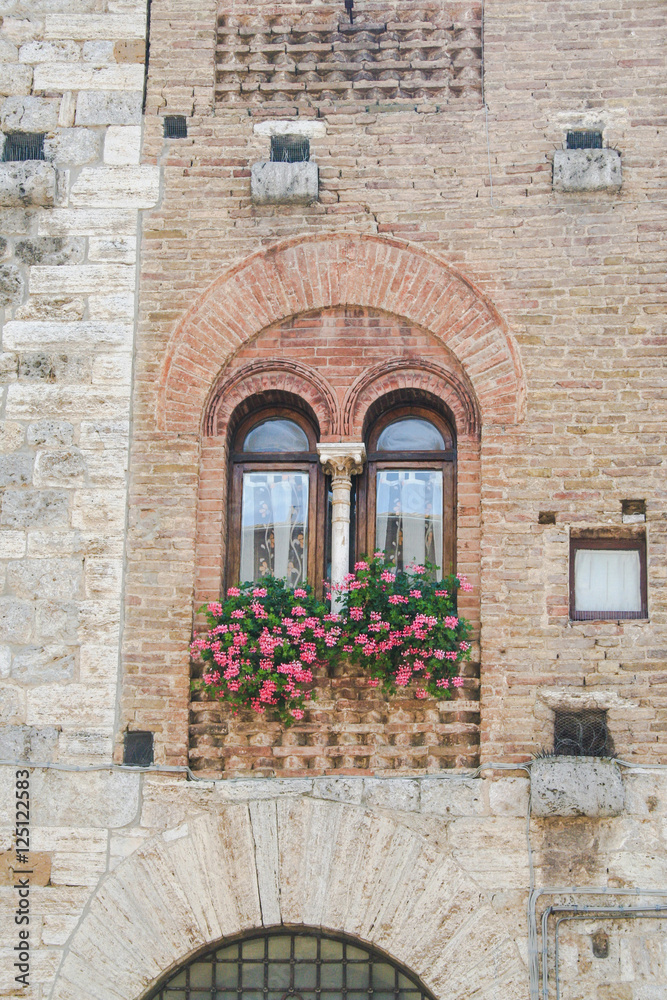 A gothic window in a medieval building of San Gimignano, Tuscany, Italy