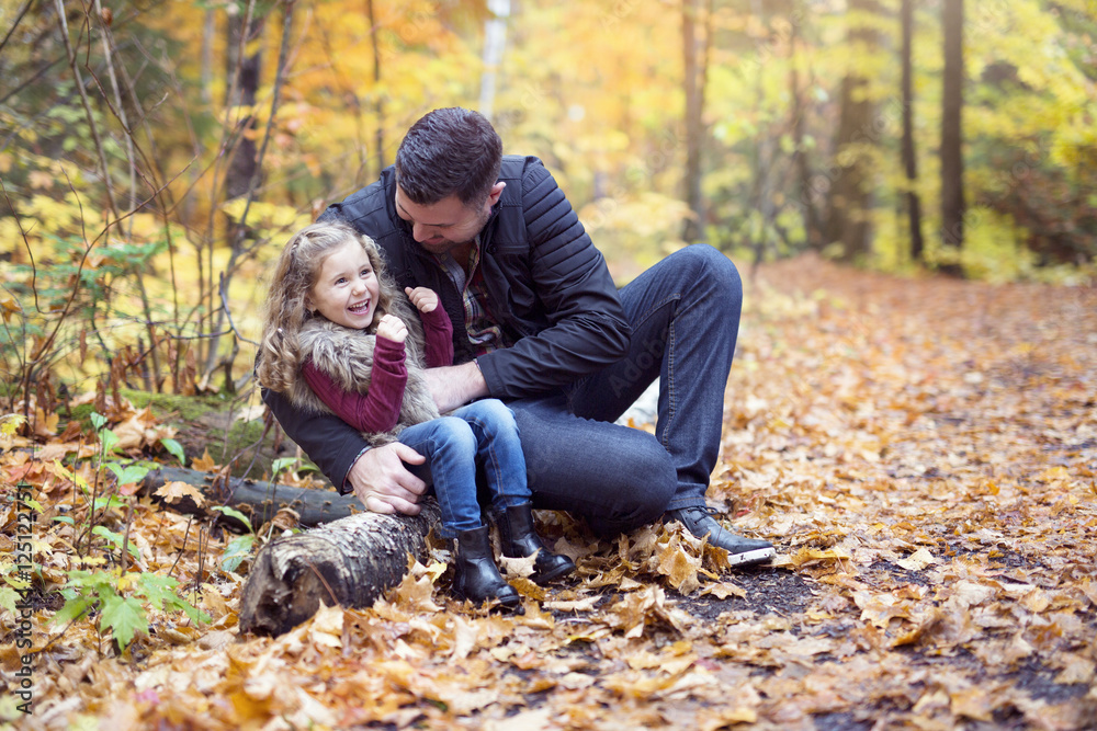 Little adorable girl with happy father in autumn park outdoors Little adorable girl with happy father in autumn park outdoors