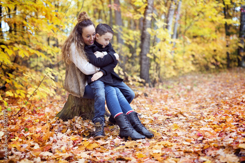 Mother with son in forest in autumn