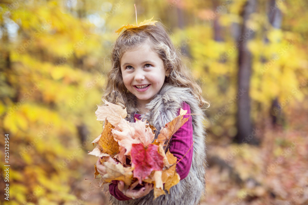 Adorable little girl in a autumn forest