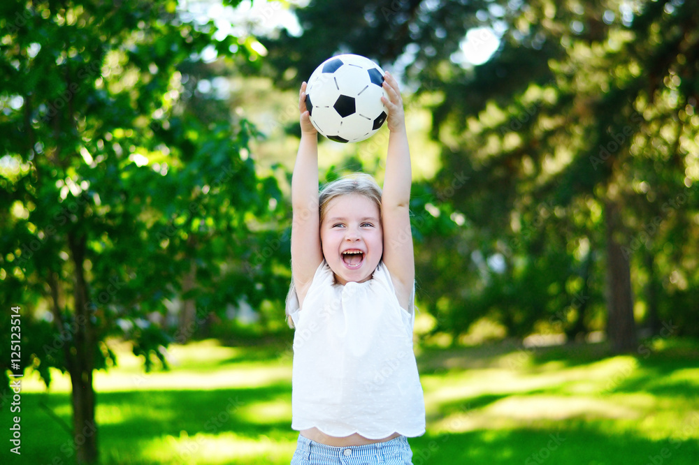Adorable little soccer fan cheering on hot summer day at park Adorable little soccer fan cheering on hot summer day at park