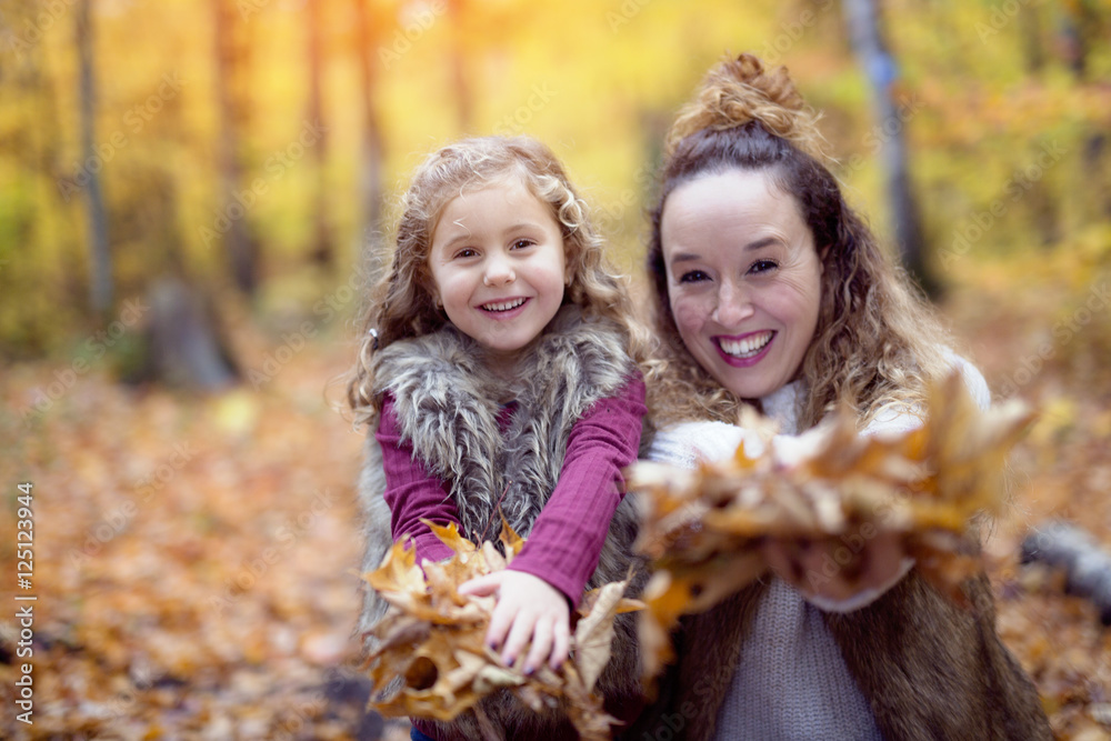 Young mother playing with her daughter in autumn park Young mother playing with her daughter in autumn park