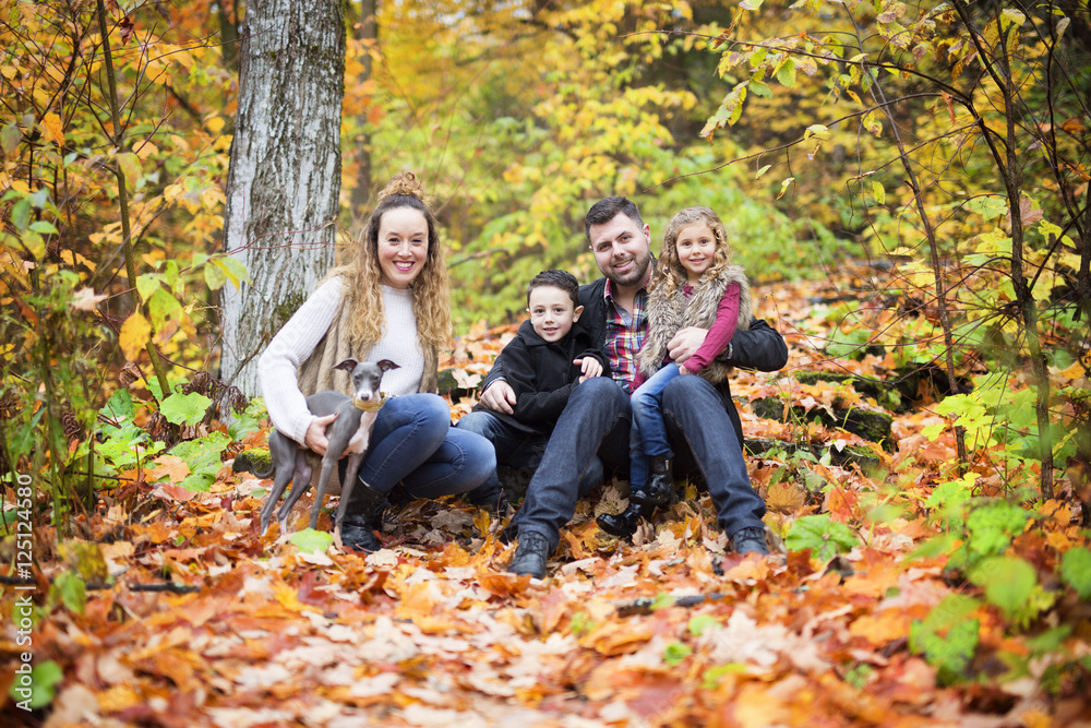 Family of four enjoying golden leaves in autumn park Family of four enjoying golden leaves in autumn park