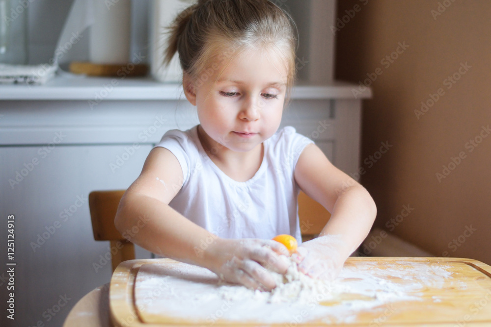 Adorable little girl making the dough for pasta Adorable little girl making the dough for pasta