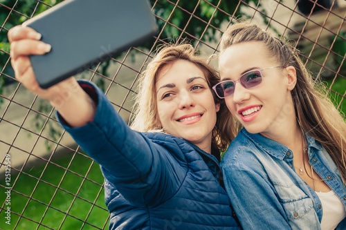 Two beautiful friends funny selfie on a tablet