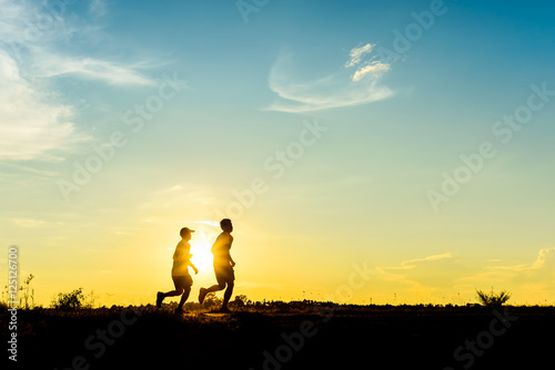 silhouette of two boys  jogging for exercise